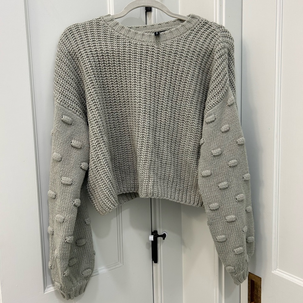 Cute grey sweater with poms on sleeves